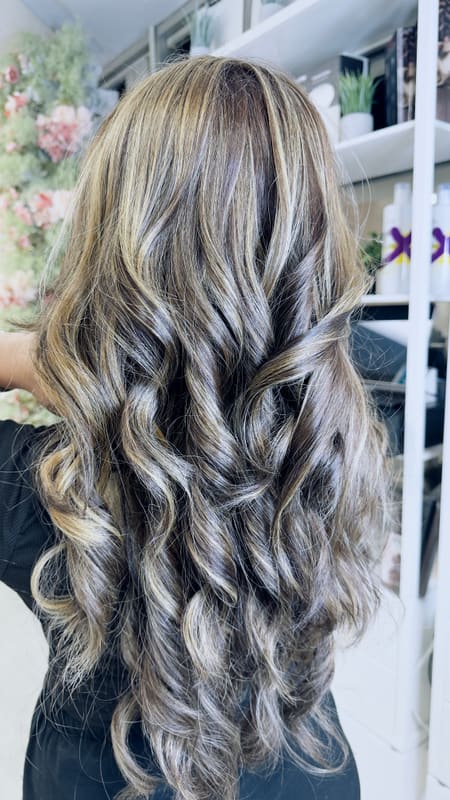 Long, curled brown hair with bright blonde highlights