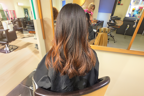Client receiving professional long hair styling at HB Beauty salon in Kitchener-Waterloo, showcasing elegant curls and polished finish