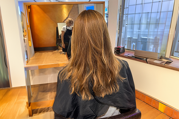 Stylist performing a root touch-up service at HB Beauty salon in Kitchener-Waterloo, precisely applying color to regrowth area